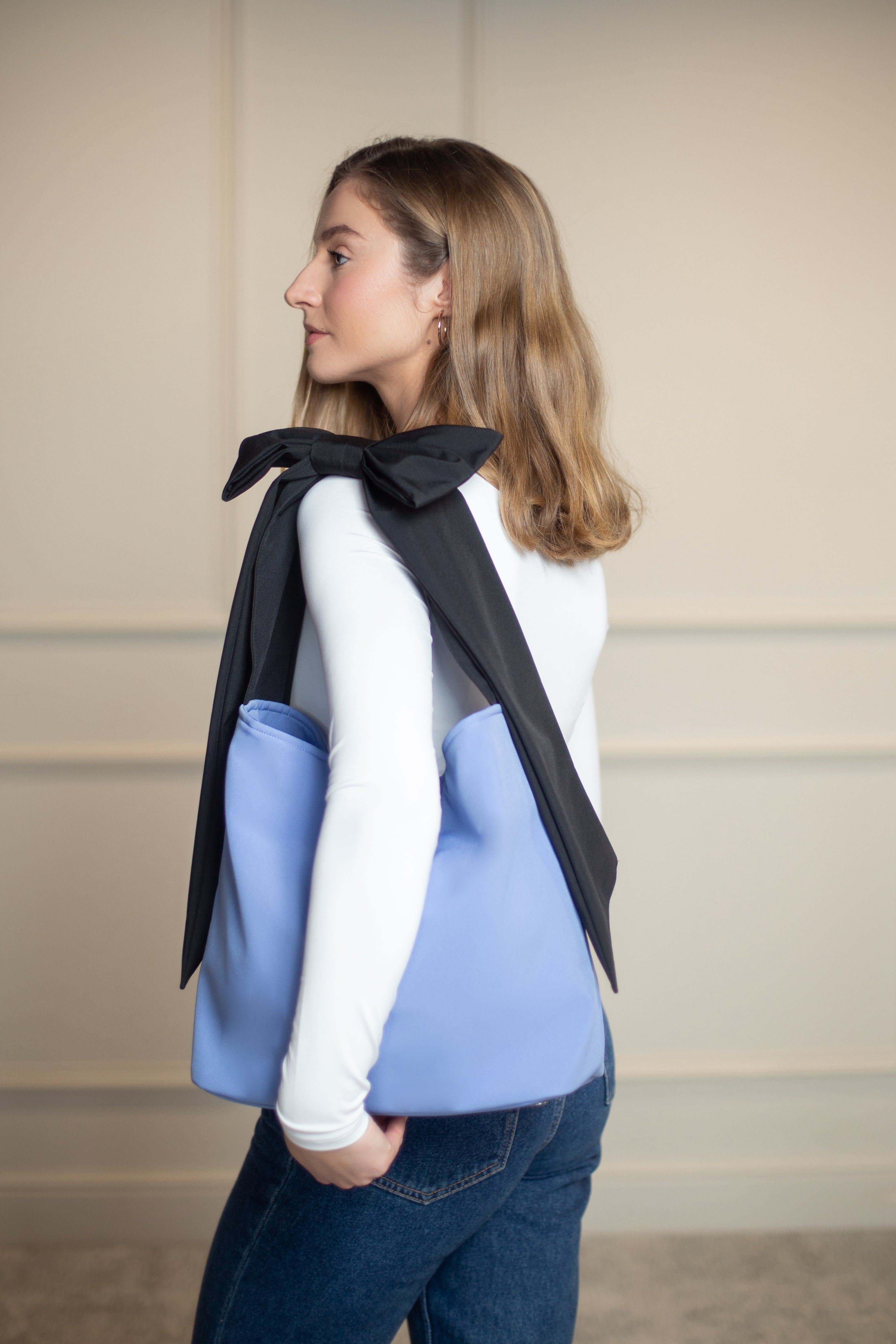 Water-resistant blue tote bag with structured interior and stainless steel feet, ideal for everyday essentials and on-the-go moments.