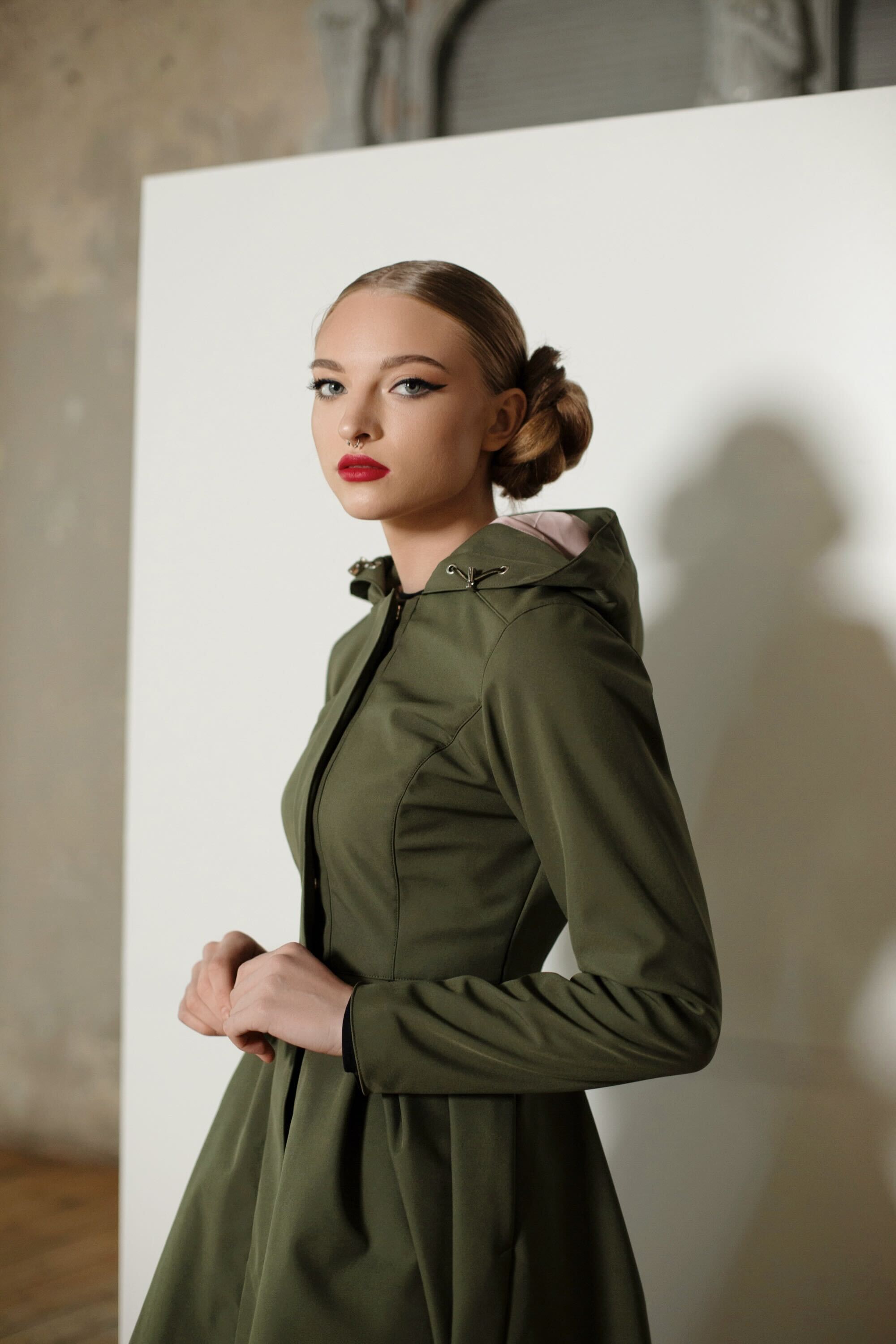 Model wearing Moss Green coat with flared pleated skirt, ideal for stylish and warm outerwear in colder weather.
