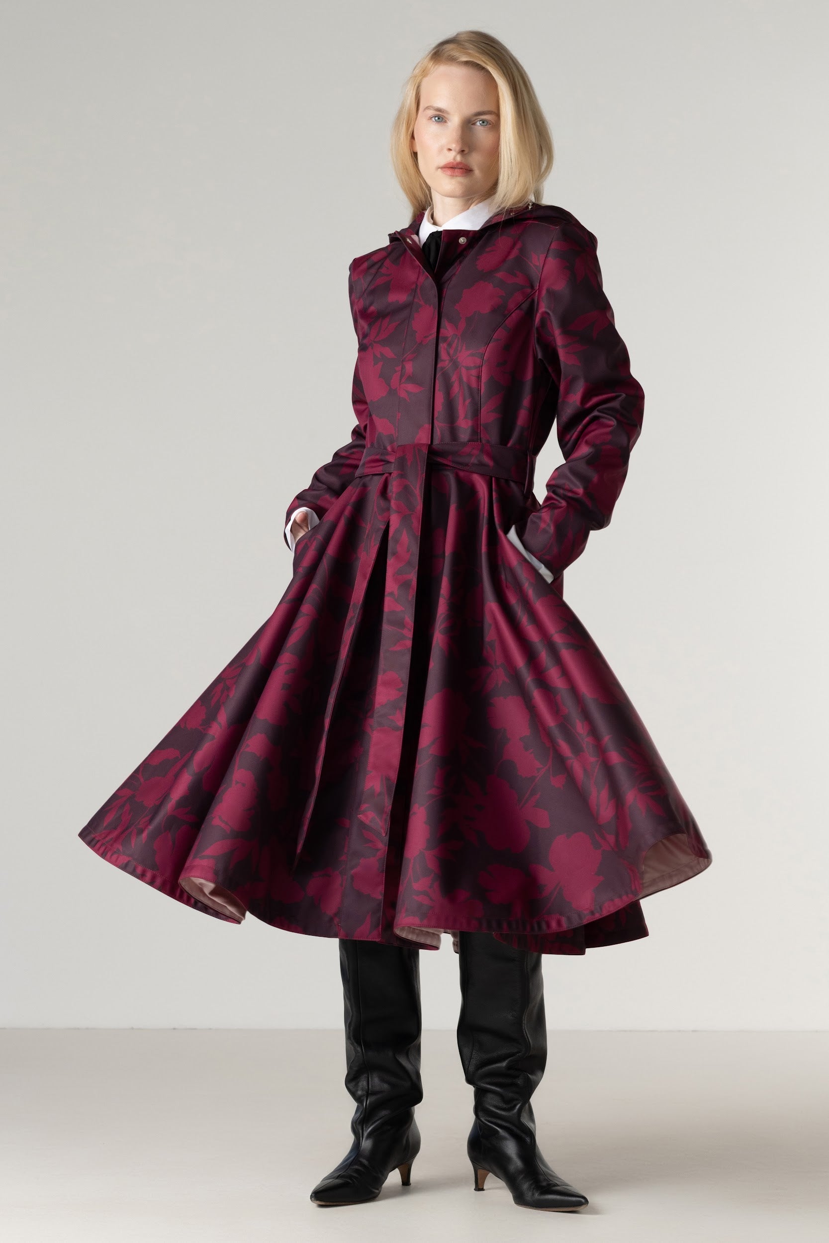 Women's burgundy floral fit and flare coat with a full circle skirt, matching tie belt, and deep wine floral print, front full-length view.