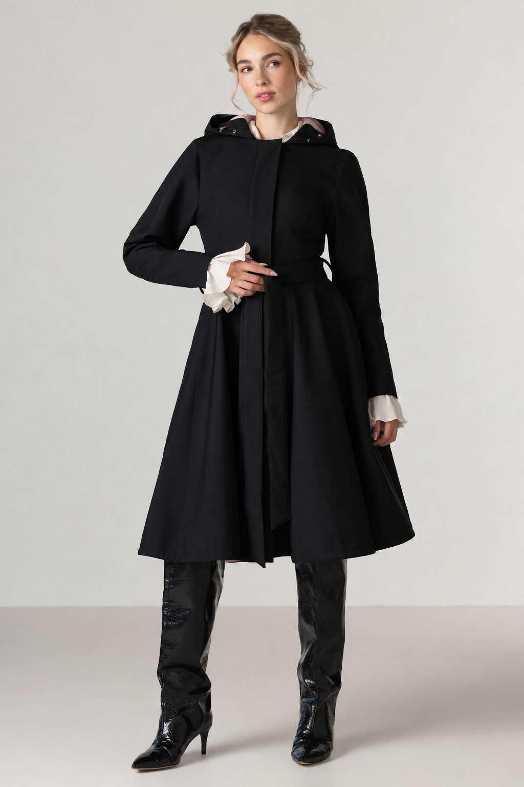 RainSisters black fitted and flrared coat Midnight Black with tie belt and dusky pink inner lining, photographed against light gray background