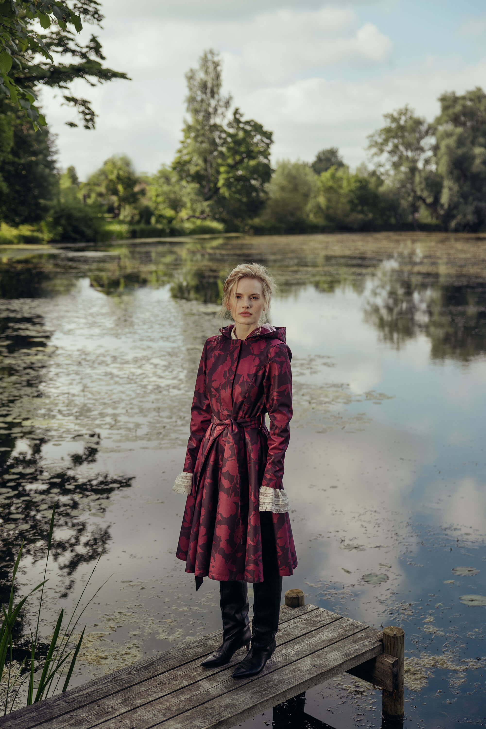 Elegant burgundy floral fit and flare coat styled outdoors, highlighting the deep wine floral print and graceful full circle skirt.