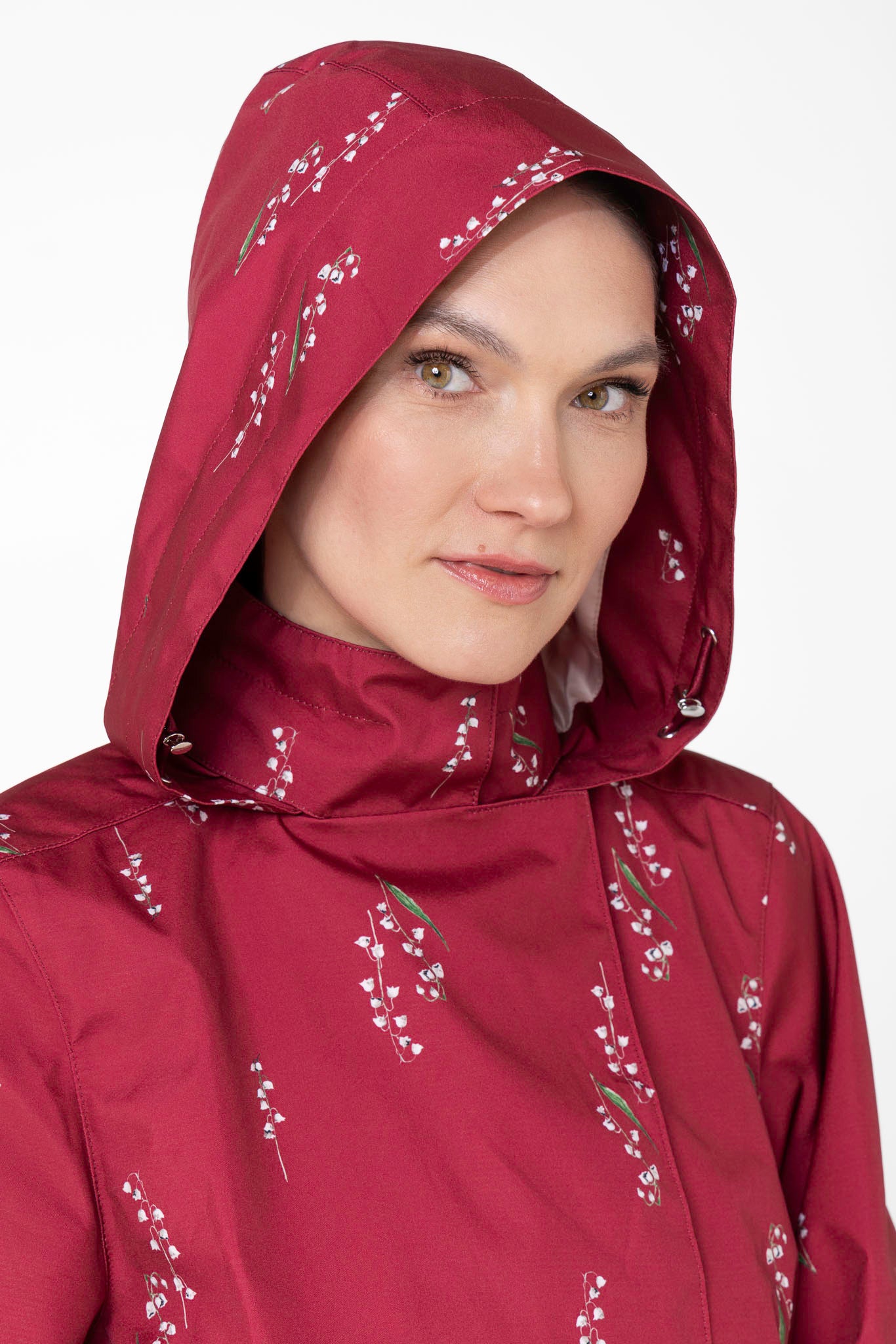 Close-up of hood detail on burgundy waterproof trench coat with lily of the valley print