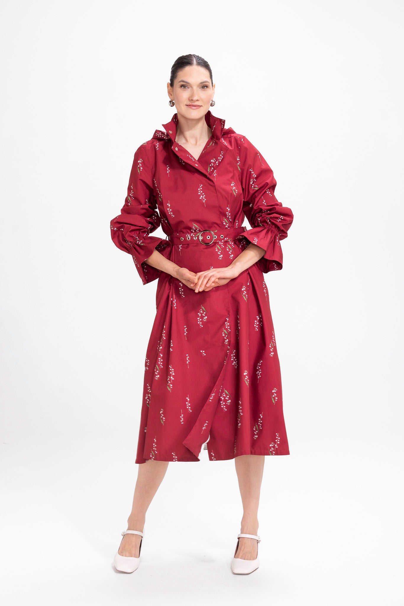 Model in motion wearing elegant burgundy waterproof trench coat with matching belt