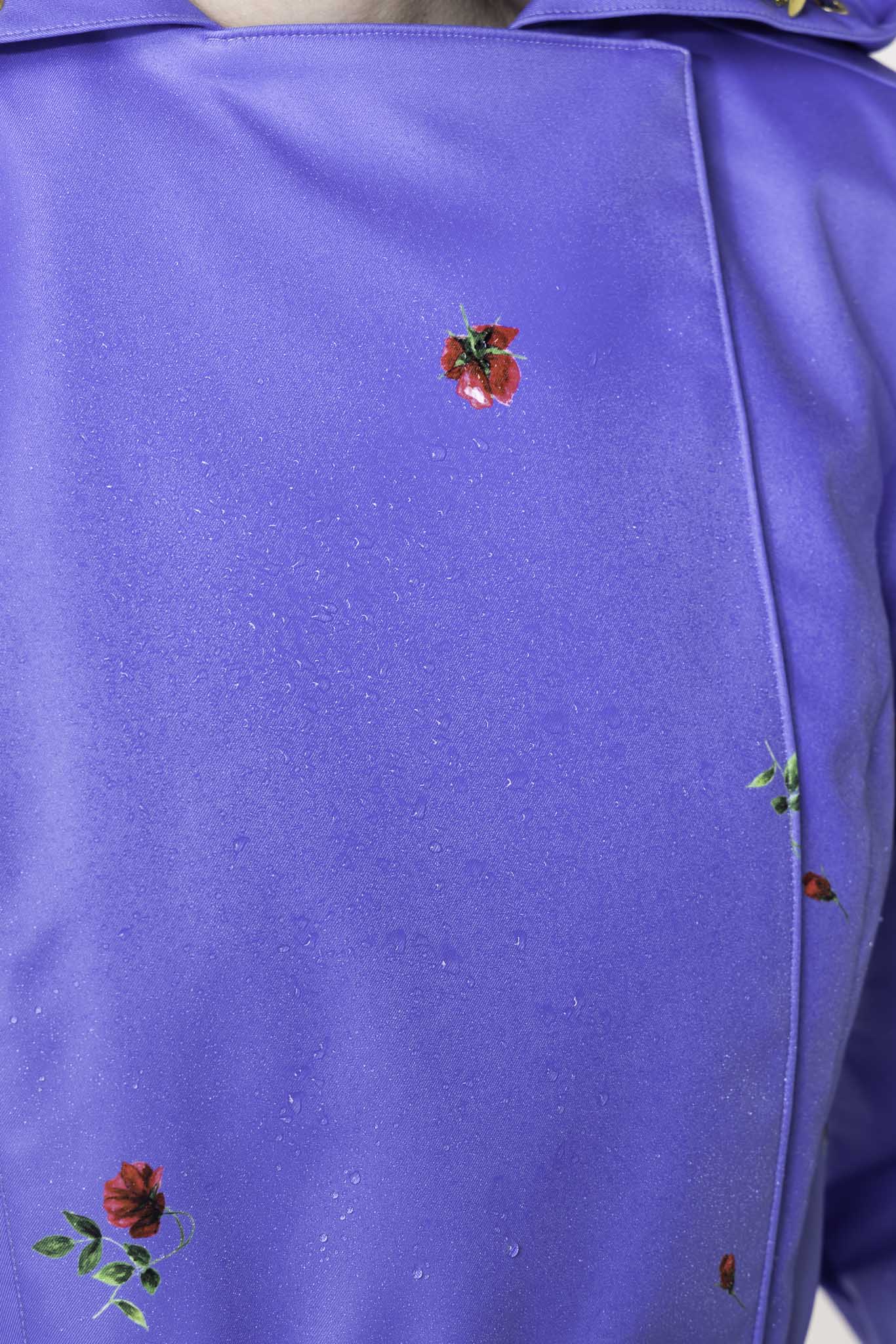 Water droplets on blue waterproof trench coat fabric showing protective outerwear performance
