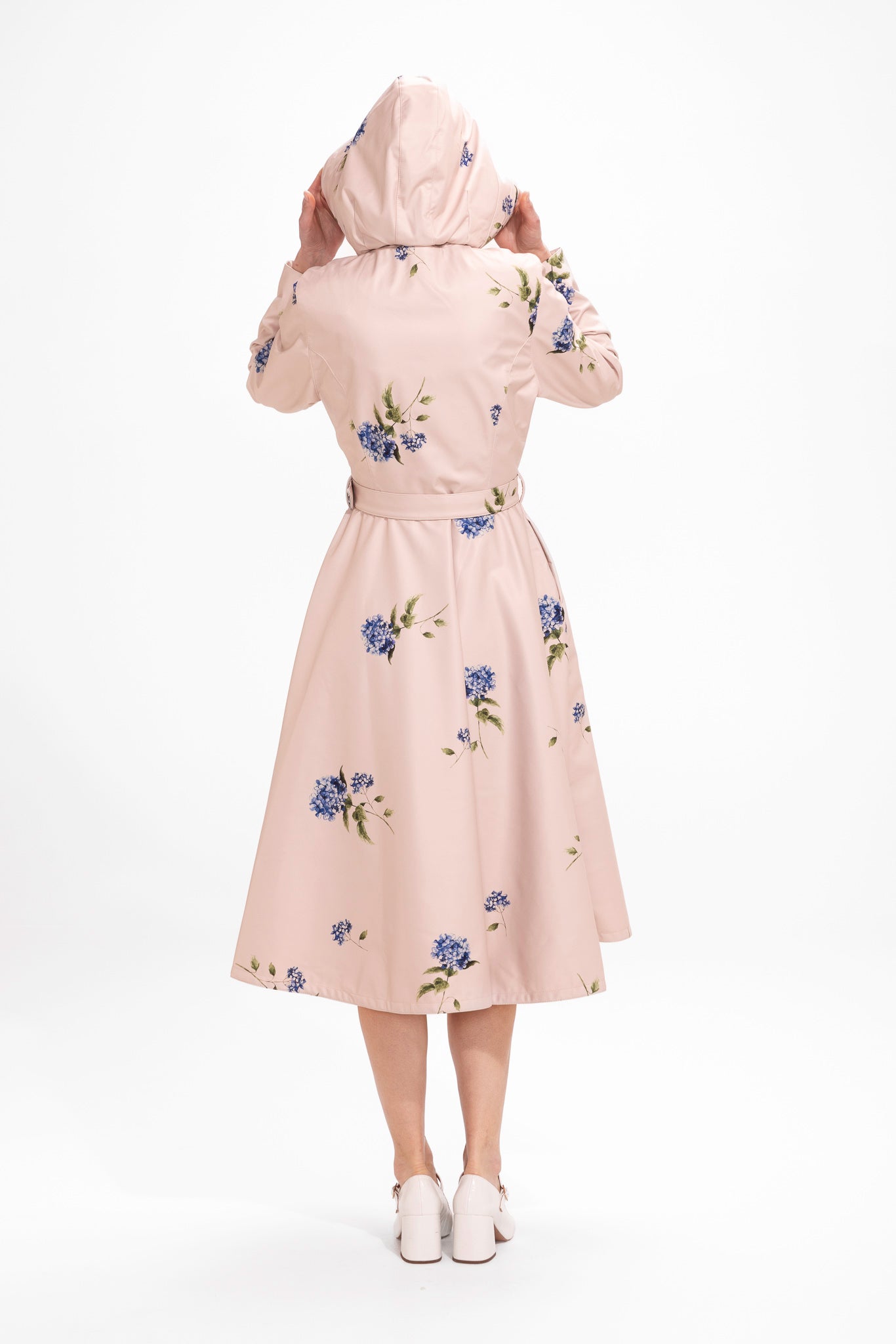 Back view of beige fit and flare waterproof women's coat with matching belt