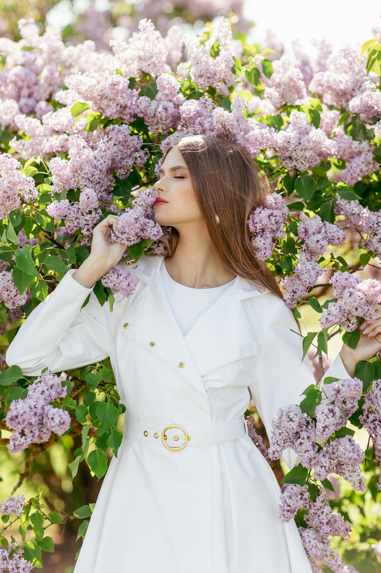 Model in motion wearing elegant white trench coat with timeless bridal-inspired silhouette