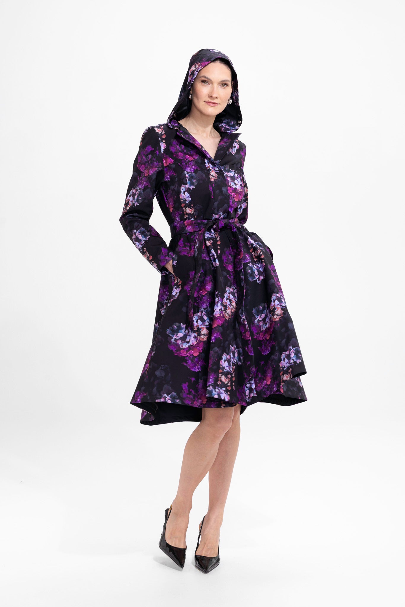 Model in motion wearing elegant black floral women's trench coat with flowing A-line silhouette