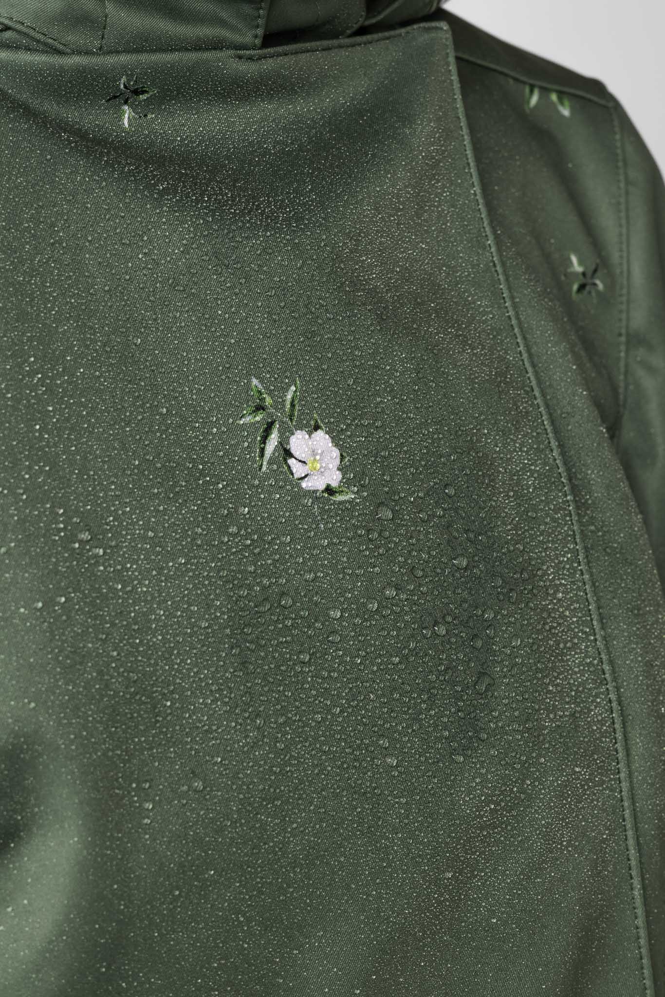 Water droplets on green water-resistant coat fabric showing breathable protection and performance outerwear