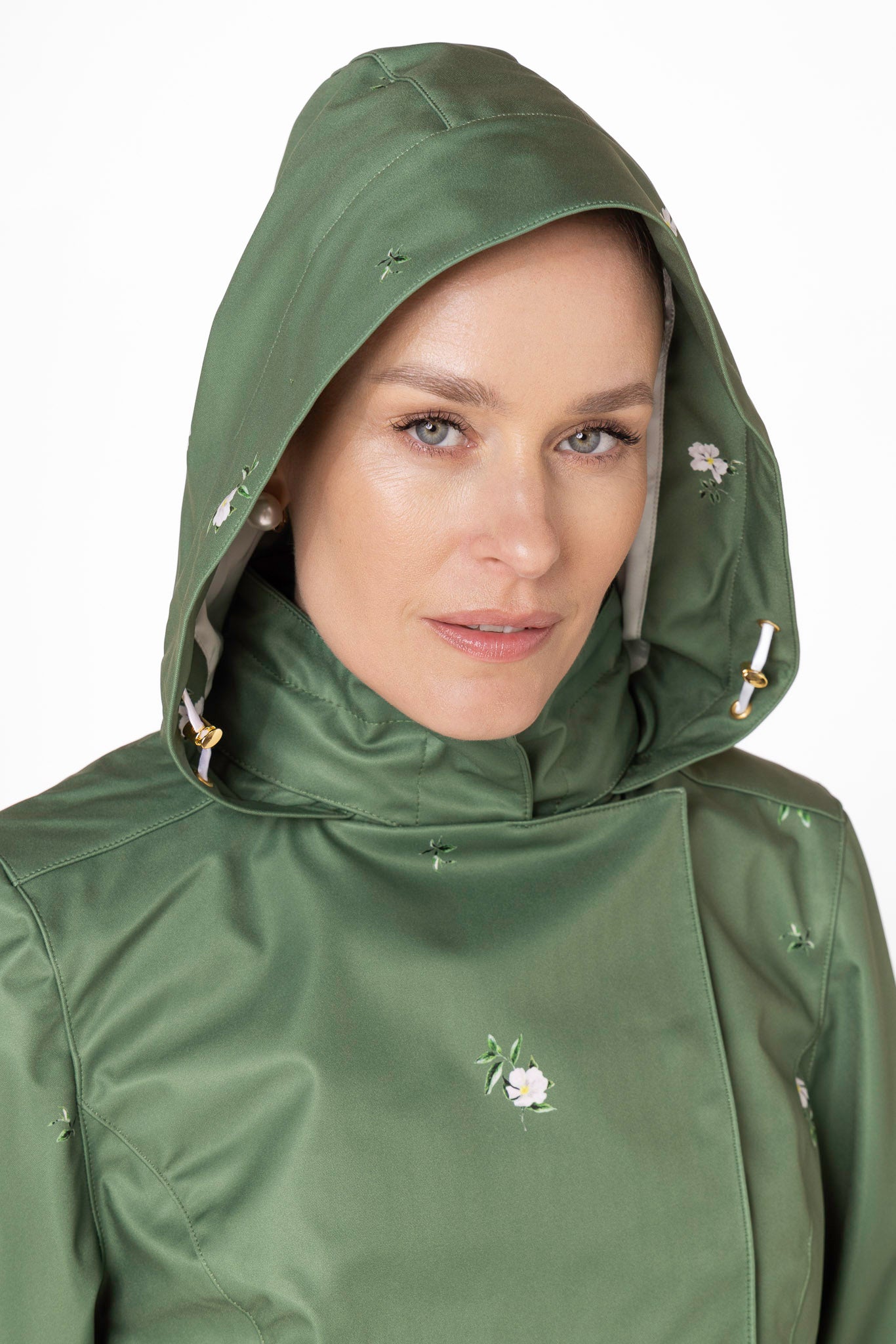 Close-up of detachable hood on Primrose Green women's waterproof short coat with white floral print