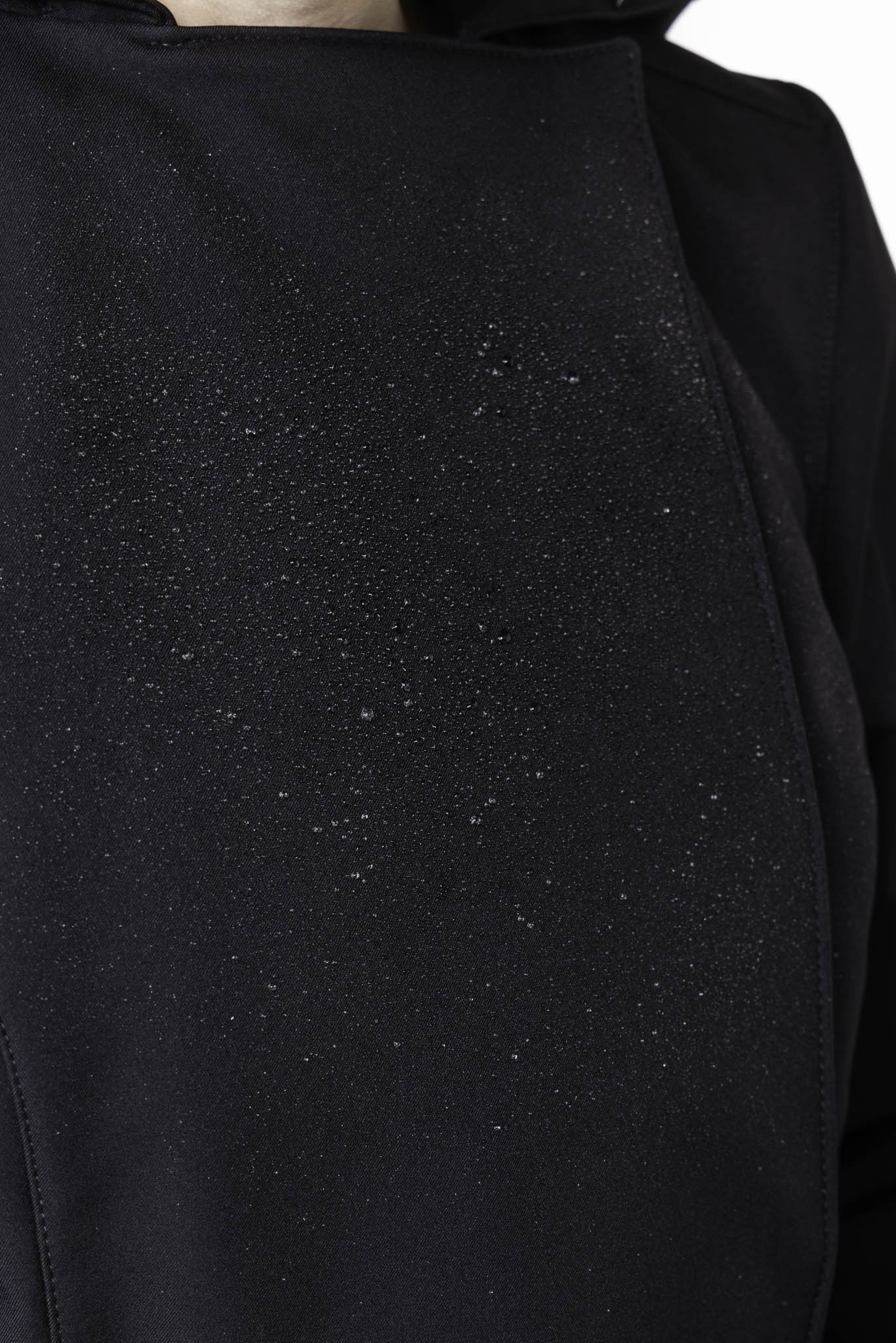 Close-up of solid black tailored waterproof outerwear fabric on women's designer trench coat