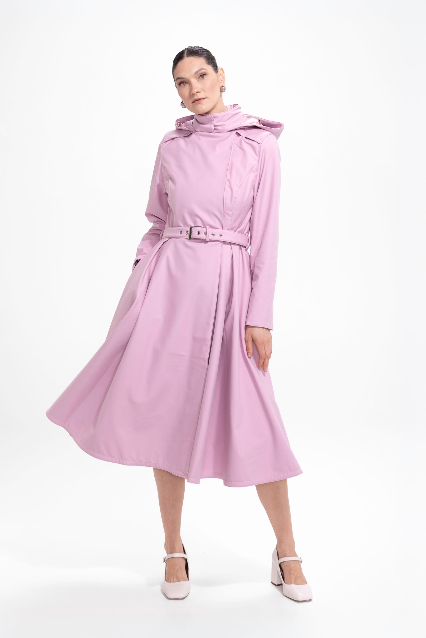 Model in motion wearing soft pink waterproof trench coat with flowing silhouette