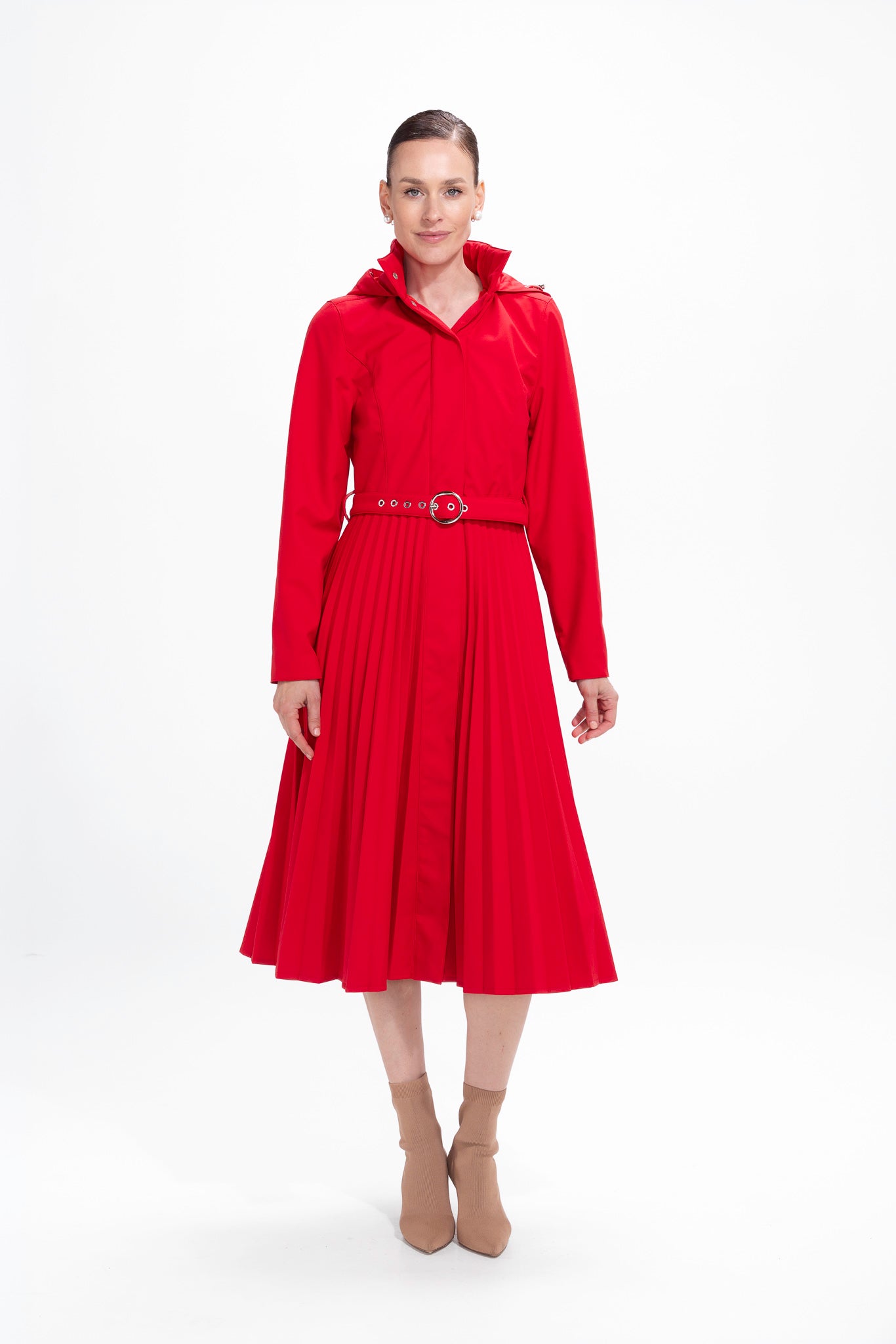 Model in motion wearing elegant red fit-and-flare women's coat with flowing pleated skirt