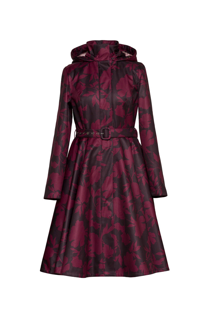 A long-sleeved hooded raincoat with a dark burgundy and dark brown floral pattern by RainSisters, featuring a matching waist belt with a silver buckle, shown on a plain white background.