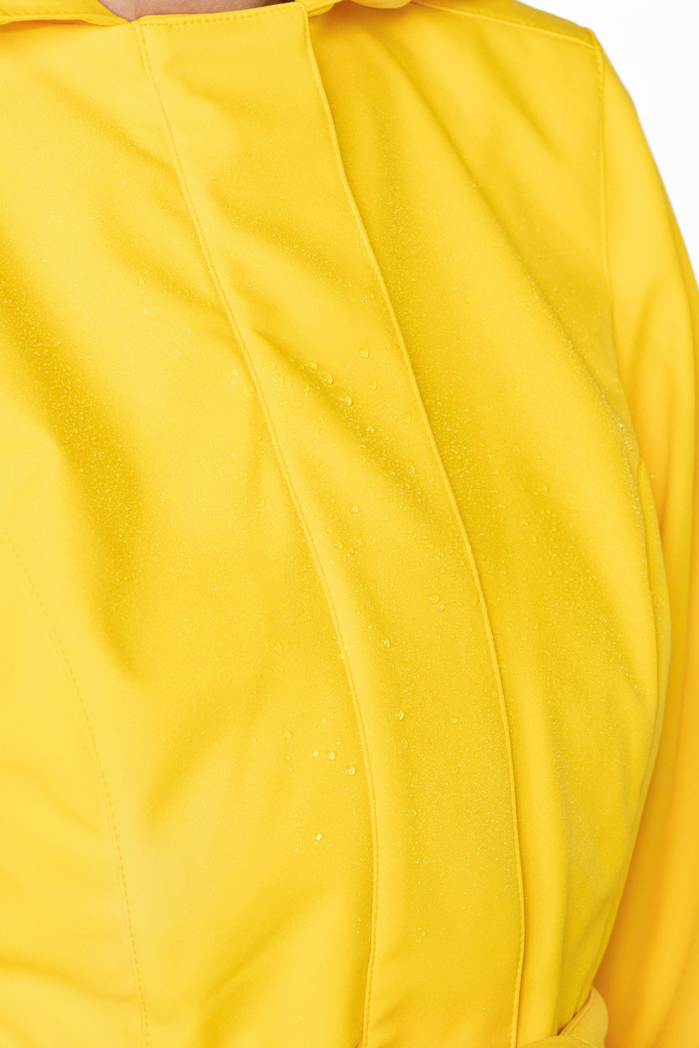 Close-up of bright yellow structured outerwear fabric on women's designer flared coat