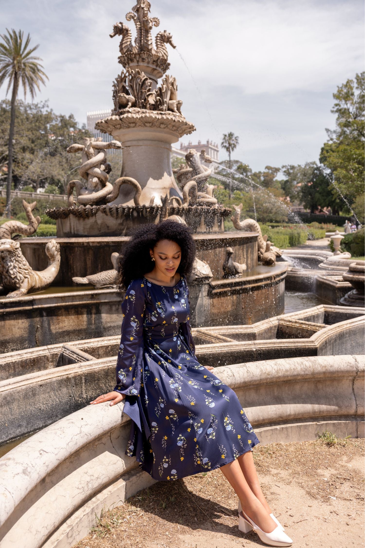 Lifestyle photo of the Meadow Dream midi dress featuring a romantic floral print and adjustable waistline