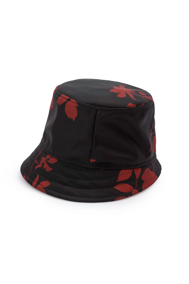A black bucket hat with a red leaf pattern, photographed on a clean white background.