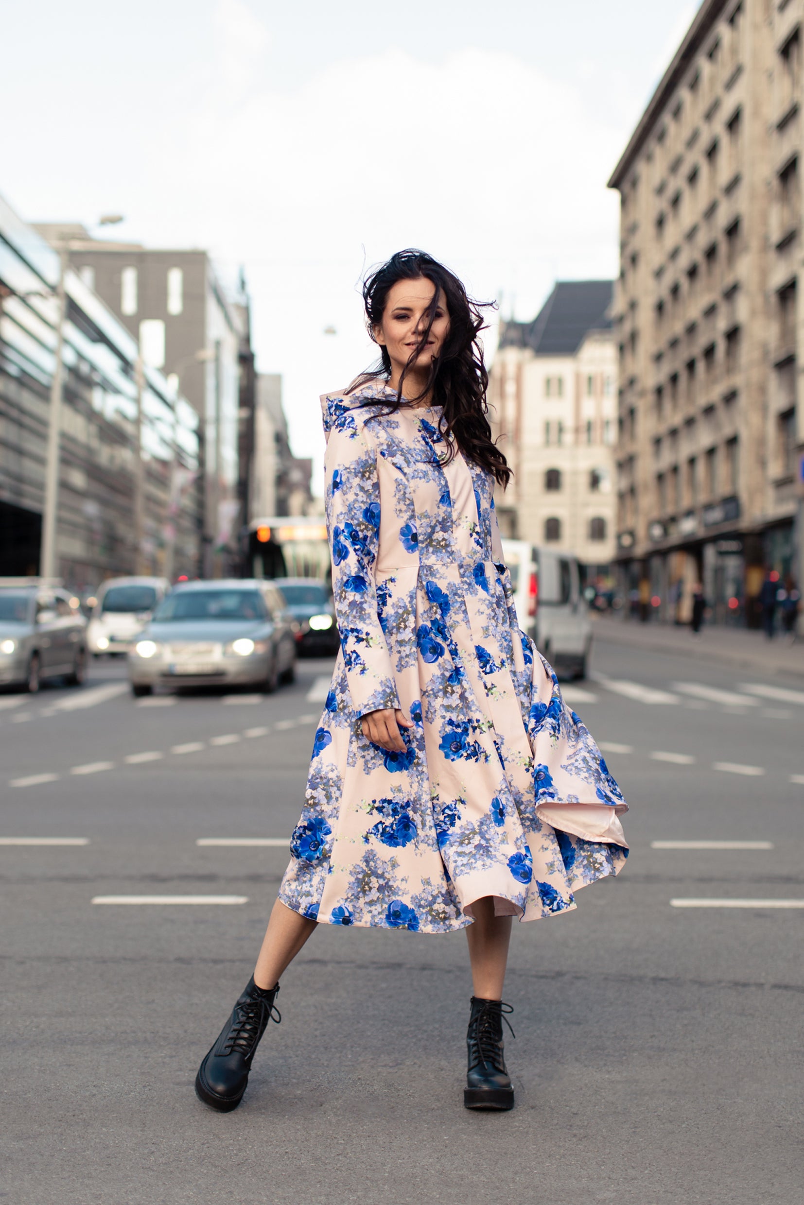 Model showcasing Cornflower Blue coat in motion – graceful A-line cut and pleated skirt flow