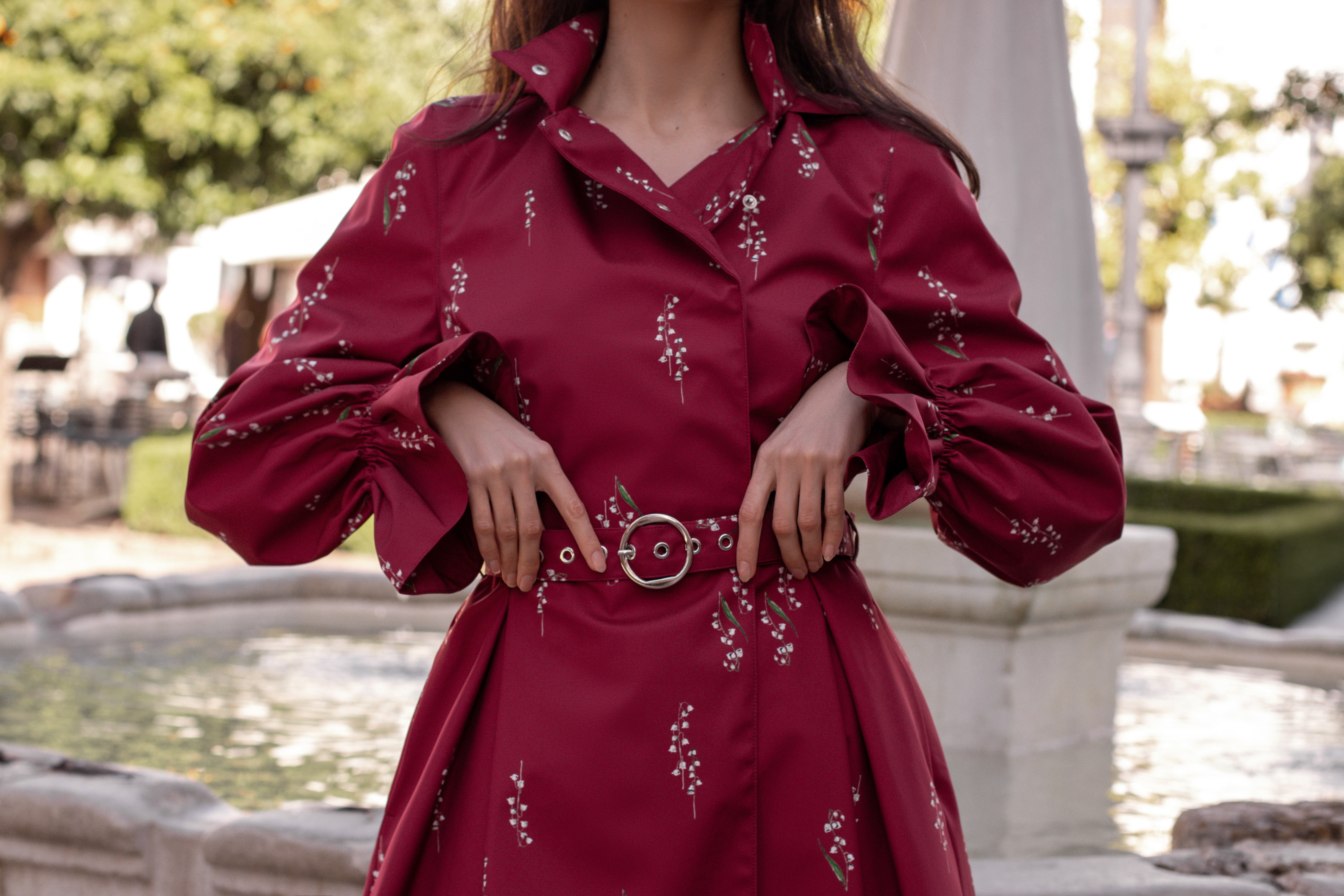 RainSisters-lightweight-coat-Crimson-Lily-dark-red-with-white-flowers-close-up-front with belt and sleeves