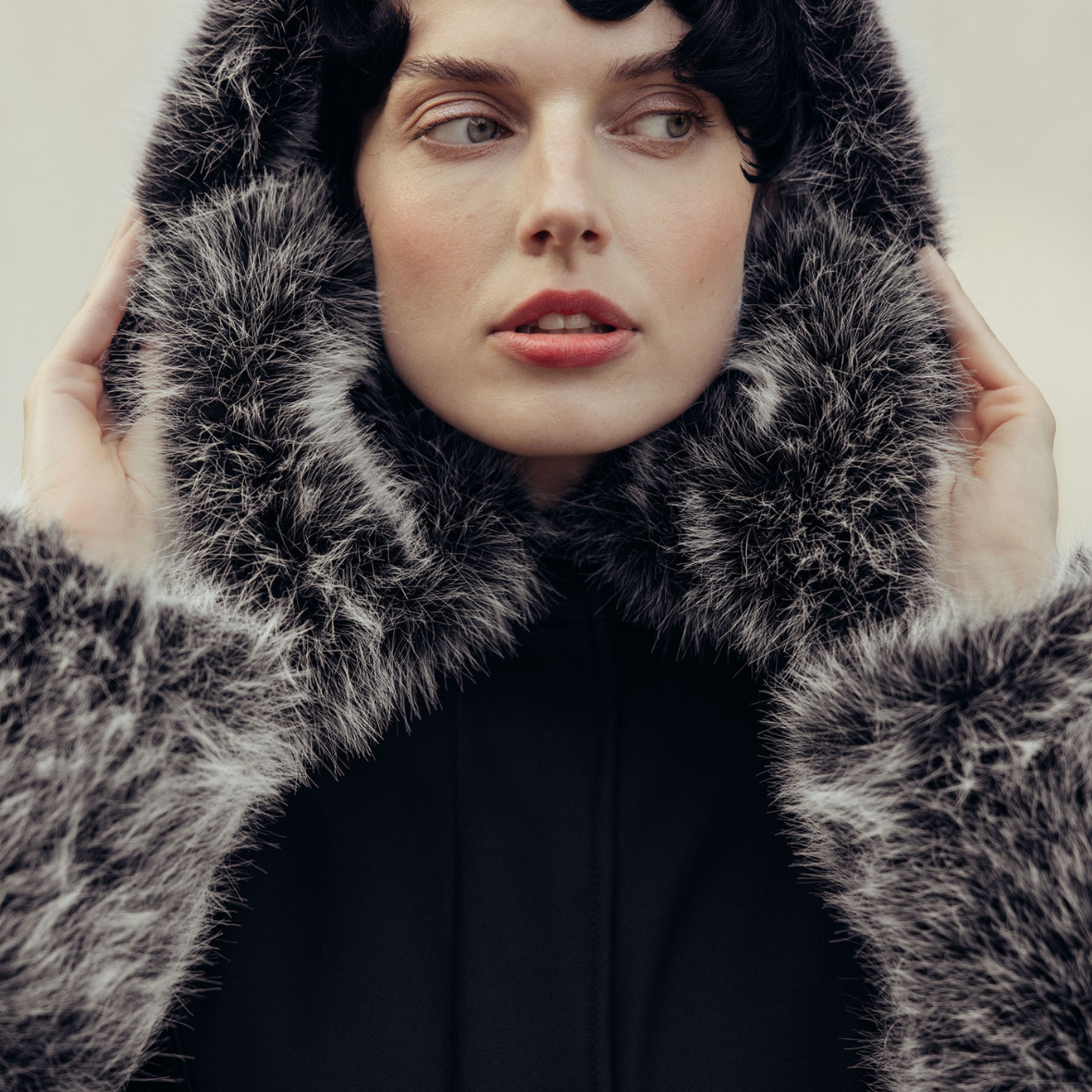 Close-up with women wearing RainSisters waterproof winter coat Frosted Muse in black with black and white faux fur details