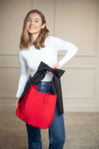 Striking red bow tote with contrasting black strap, adding a bold and graceful touch to everyday or dressy looks.