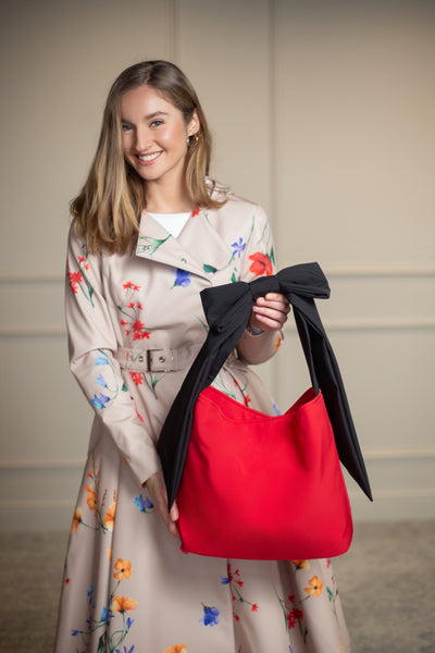 Chic red tote with black bow-accented strap, matches beautifully with RainSisters coats.