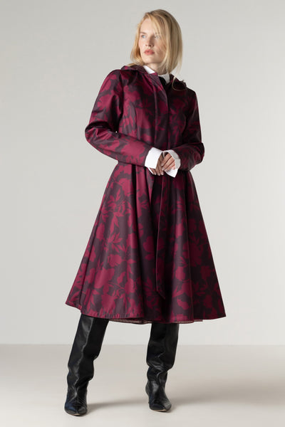 Full-length view of a women's burgundy floral coat with a fitted bodice, full circle skirt, matching tie belt, and deep wine floral print.