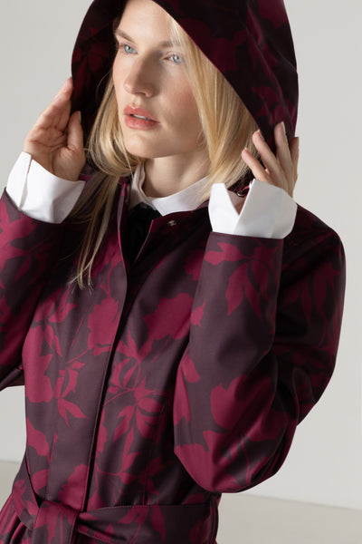 Women's burgundy floral coat with a removable hood close-up, full circle skirt, matching tie belt, and deep wine floral print.