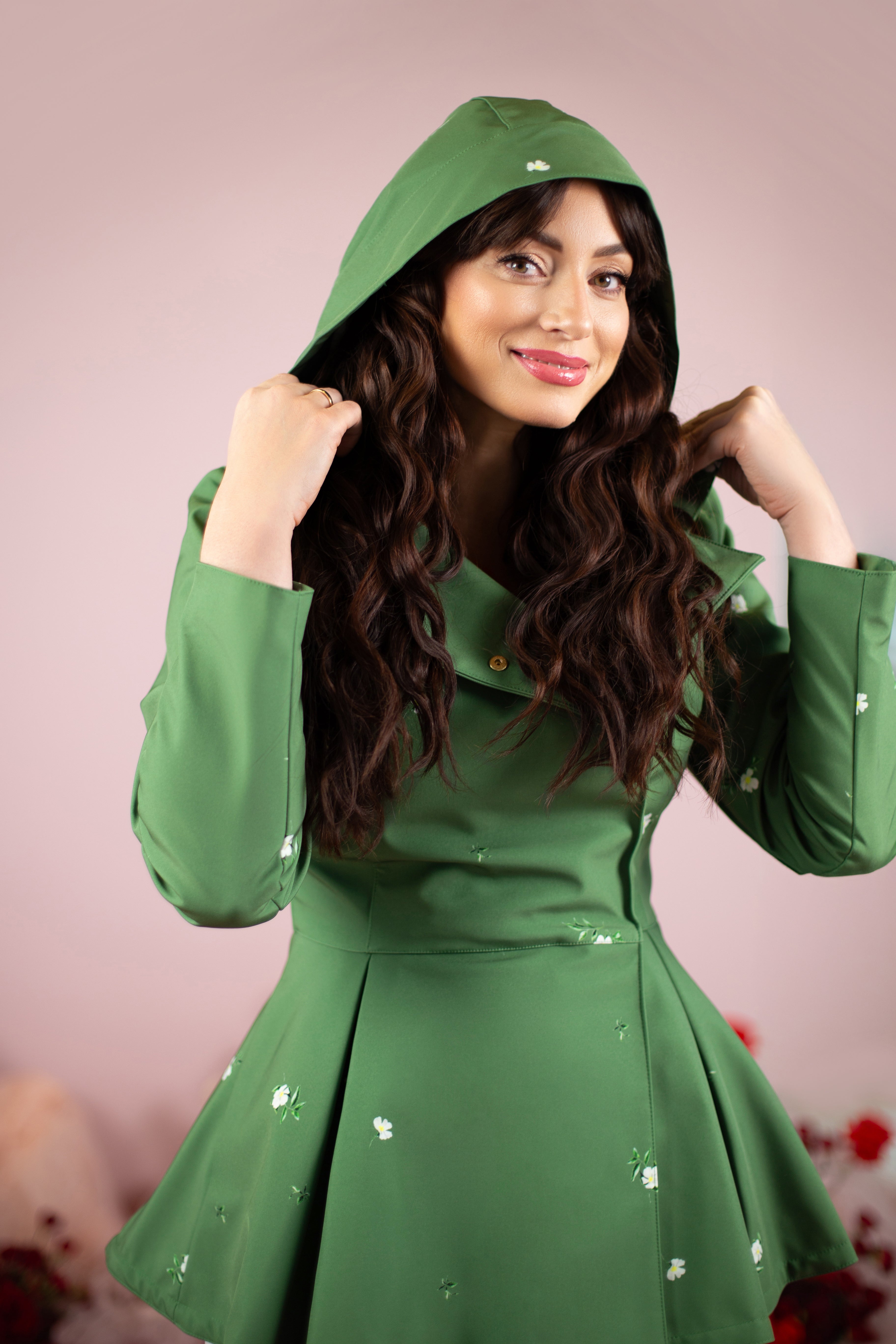 Woman wearing a green hooded outfit with a plain background
