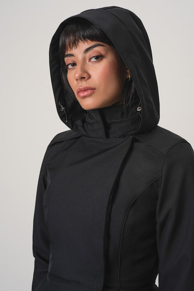 A close-up shot of a model wearing RainSisters black hooded jacket Moonlit Bow against a light gray studio background.