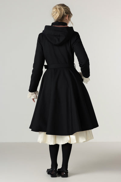 A model wears the Winter Midnight Black fit-and-flare waterproof winter coat with a feminine full skirt.