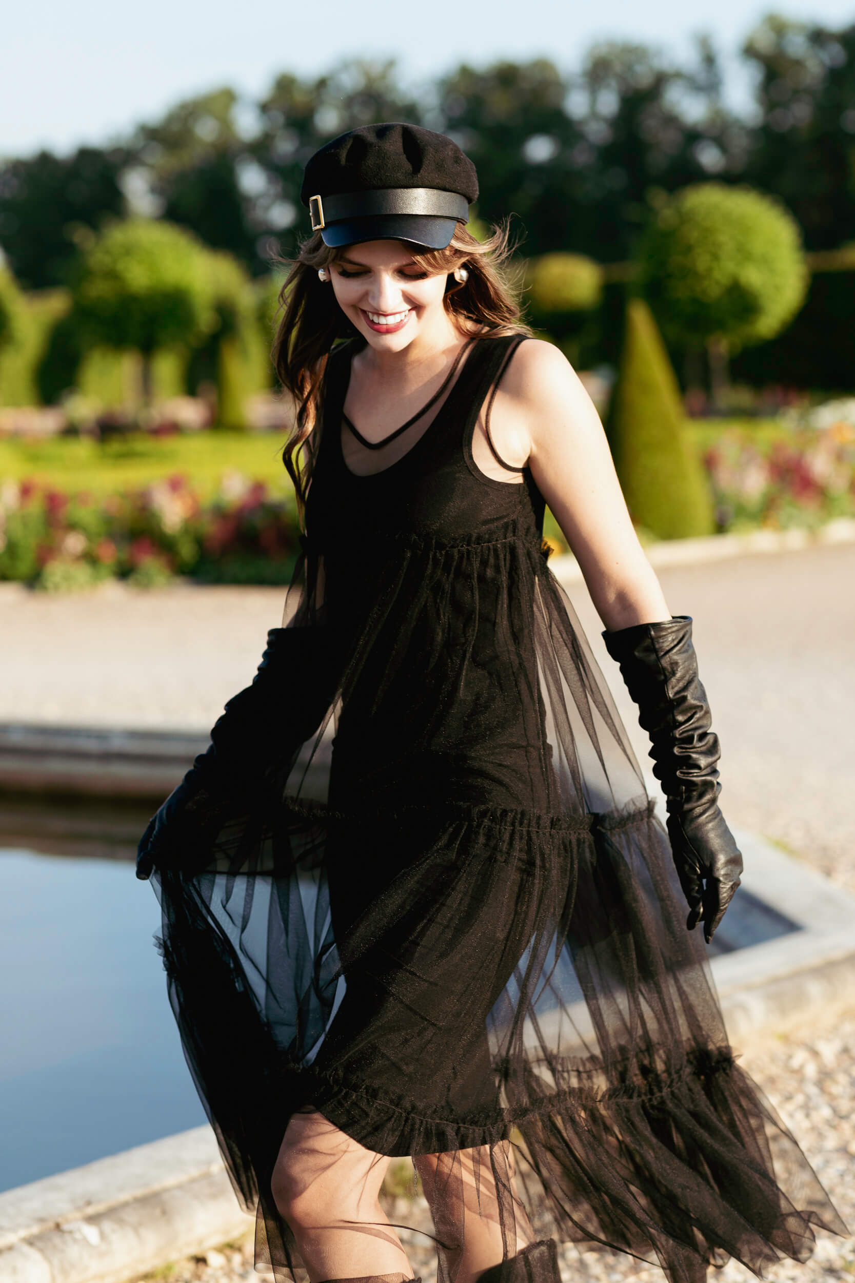 Woman in a black tulle dress standing in a garden
