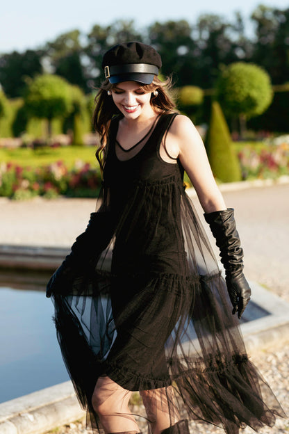 Woman in a black tulle dress standing in a garden