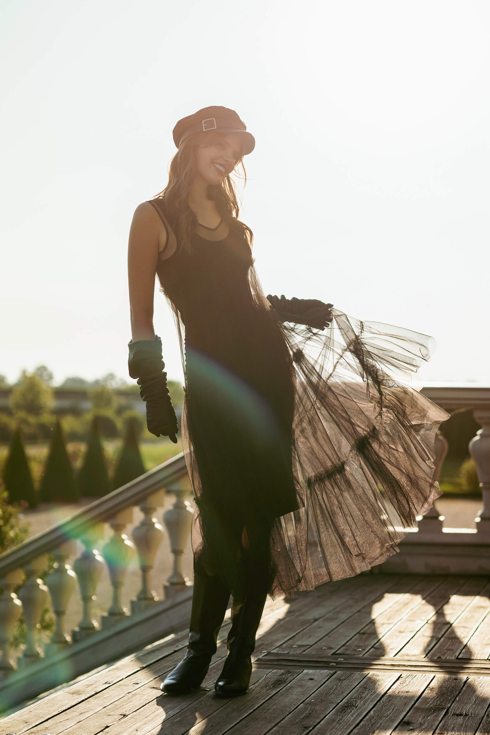 Woman holding a dress on a wooden deck 