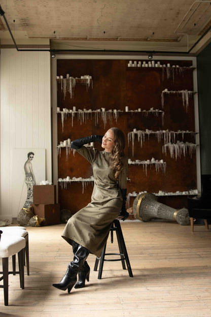 Green polka dot midi dress in satin with gathered shoulders and slim feminine fit, perfect for romantic occasions.