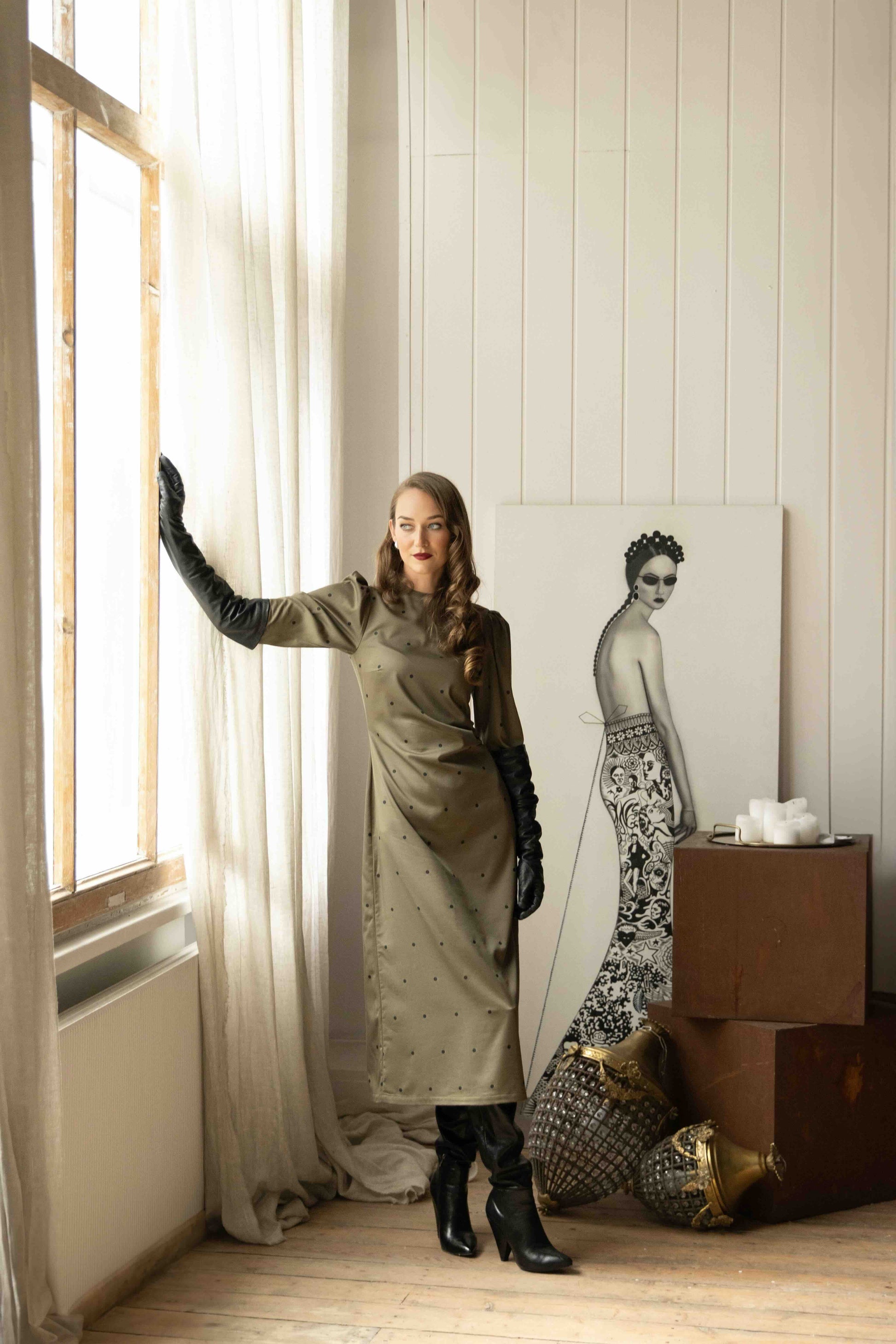 Elegant midi dress with long sleeves, circular back cutout tied with ribbon, and flowing skirt with back slit.