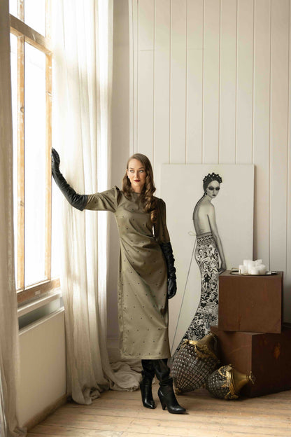 Elegant midi dress with long sleeves, circular back cutout tied with ribbon, and flowing skirt with back slit.