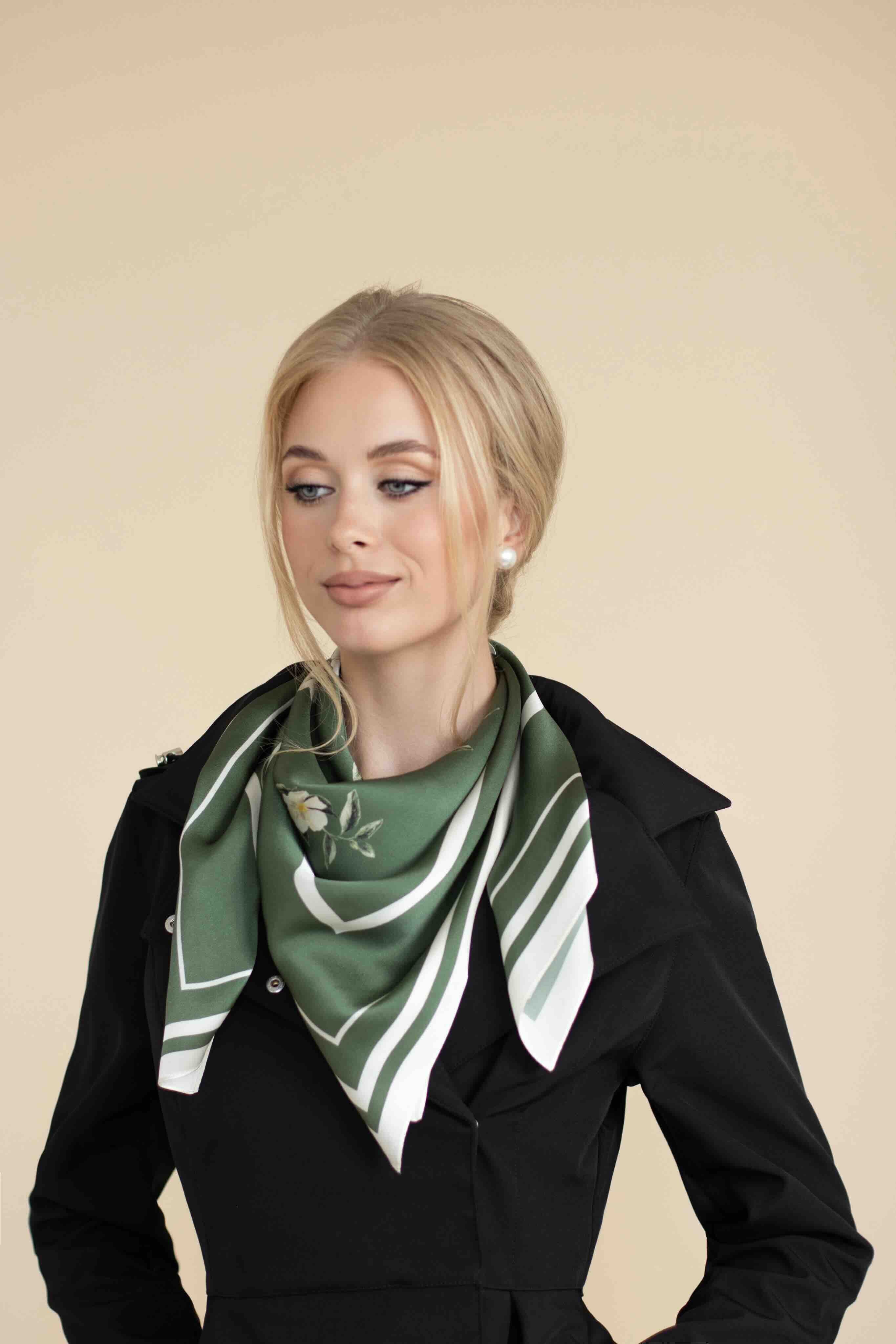 Woman wearing a green and white patterned scarf on a beige background
