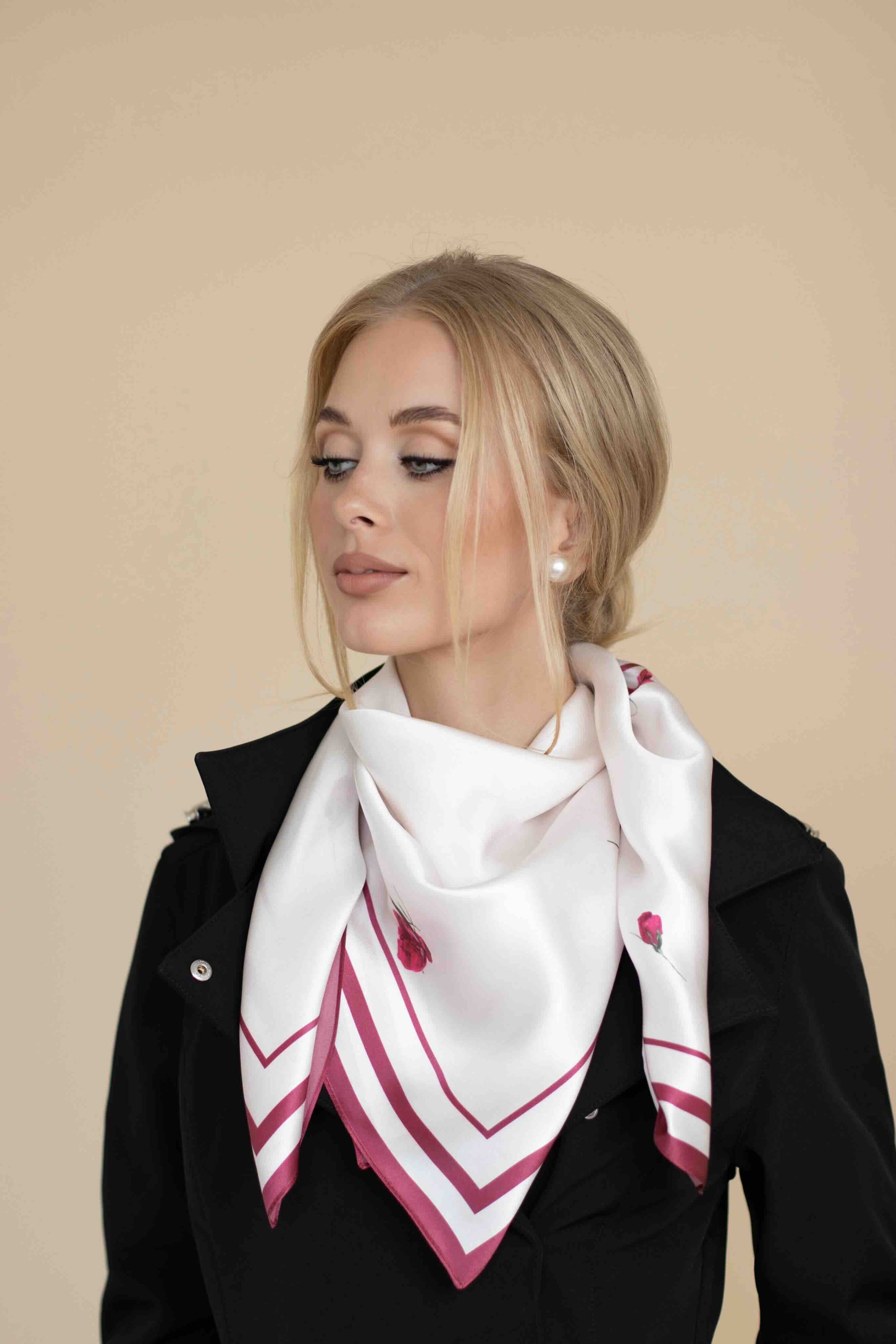 Woman wearing a white scarf with red patterns on a beige background