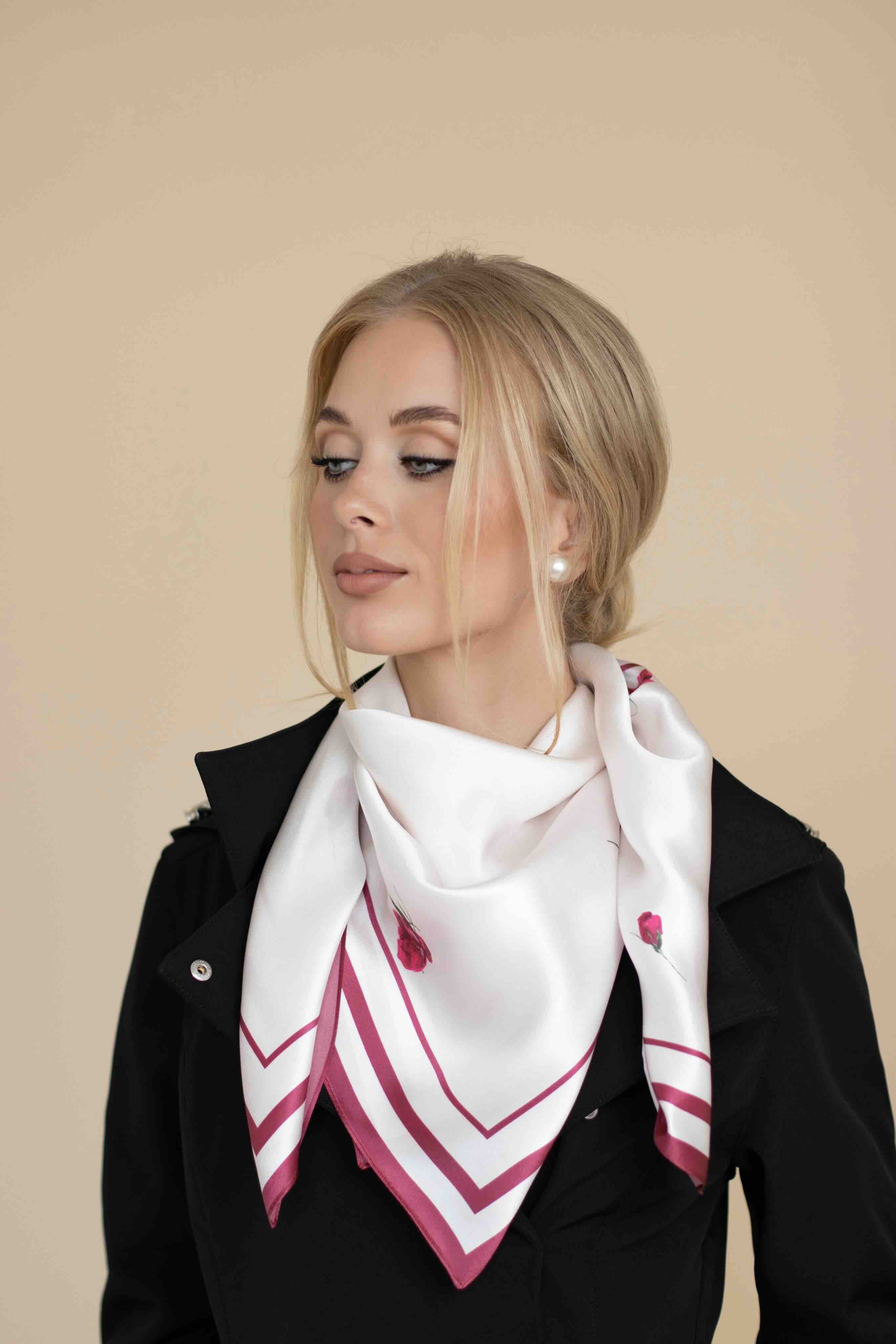 Woman wearing a white scarf with red patterns on a beige background