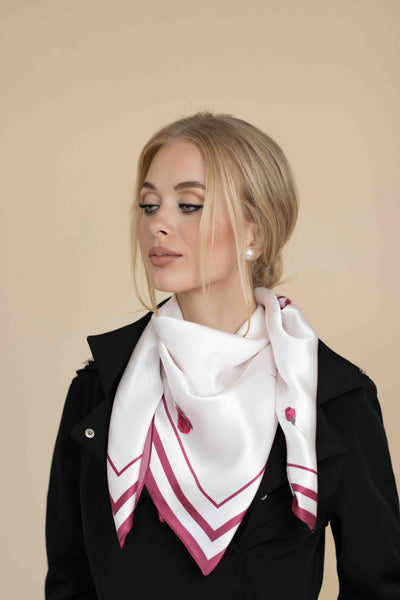 Woman wearing a white scarf with red patterns on a beige background