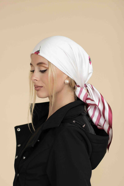 Woman wearing a white headscarf with red patterns on a beige background