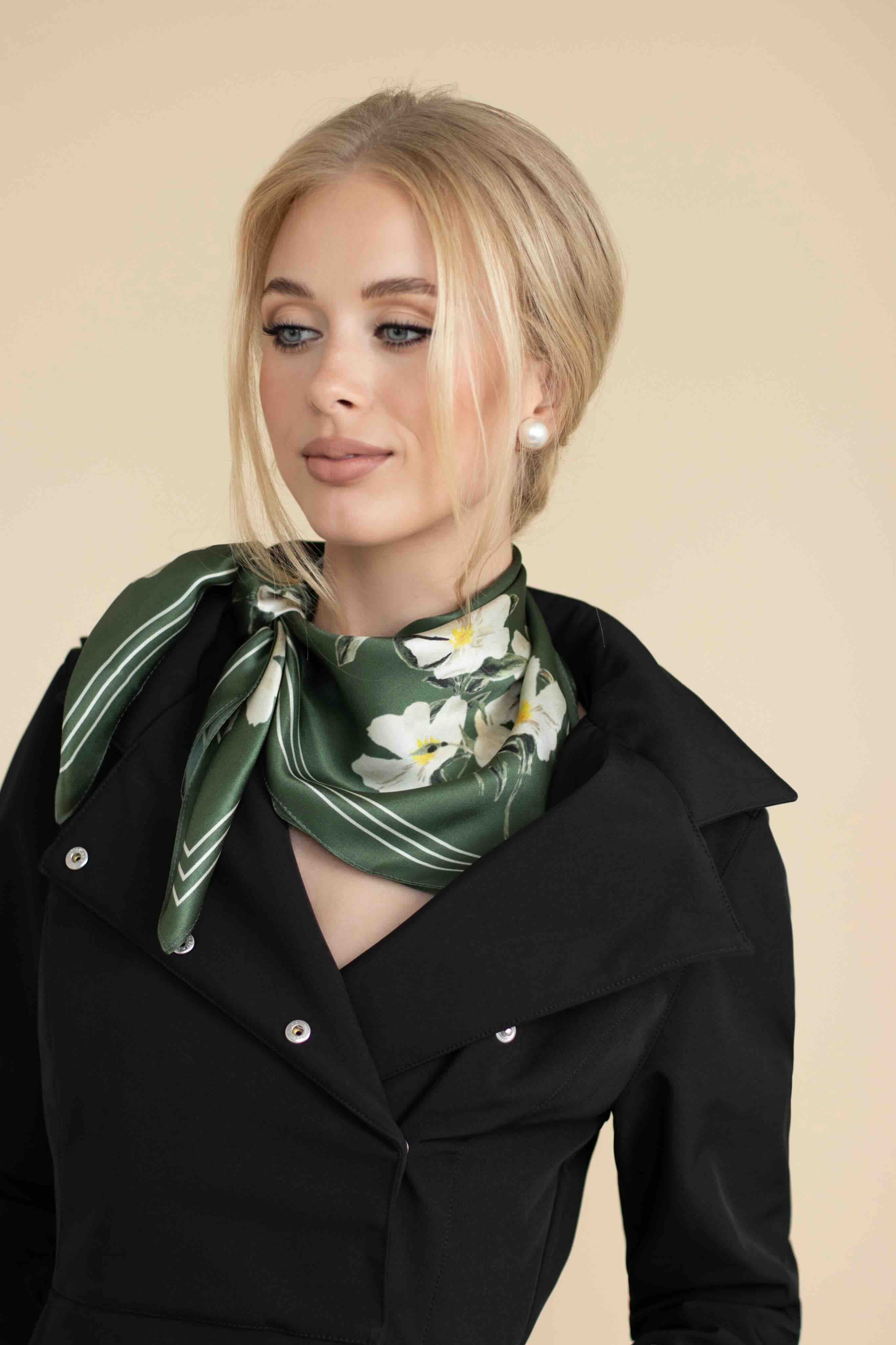 Woman wearing a green floral scarf on a beige background