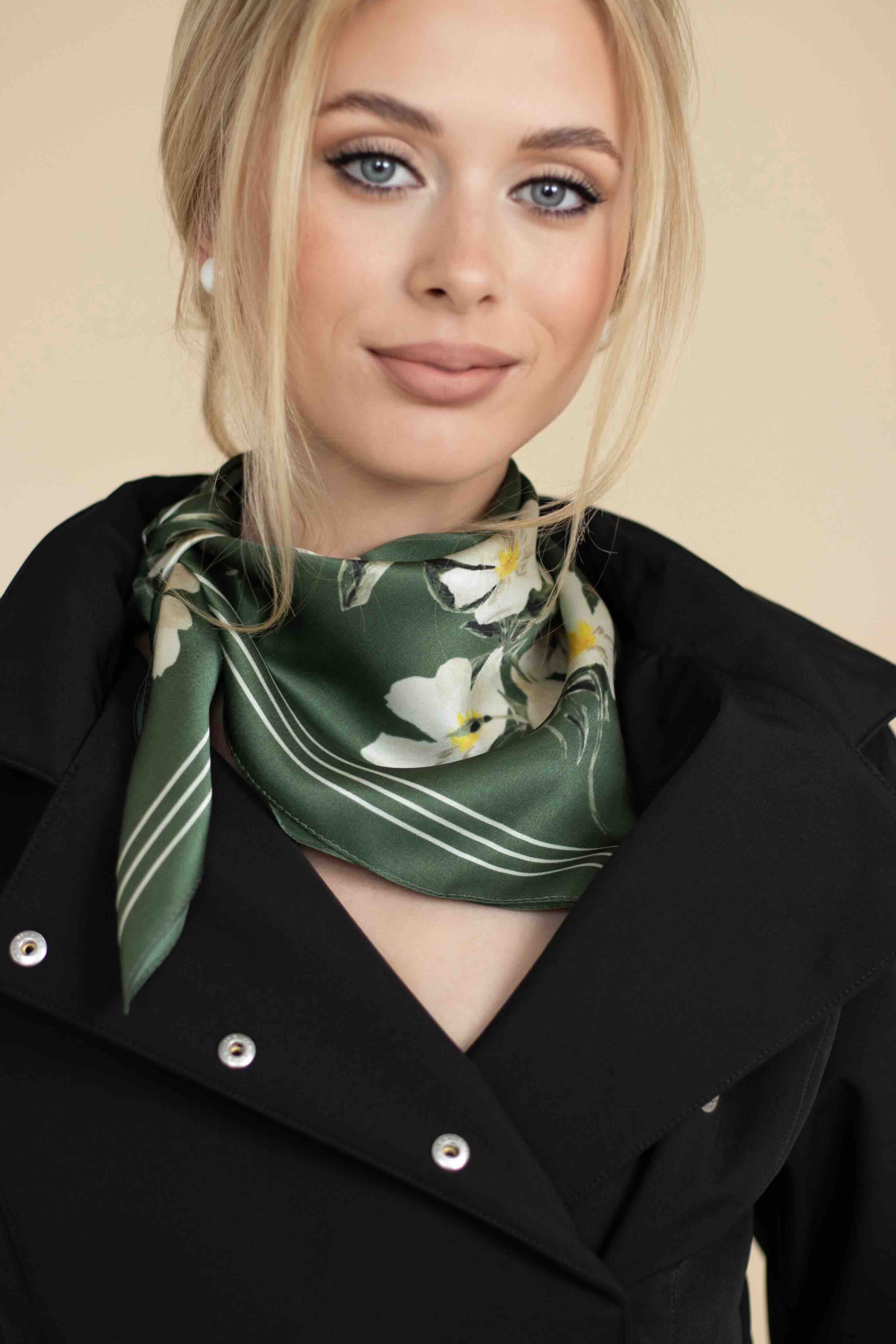 Woman wearing a green floral scarf on a beige background