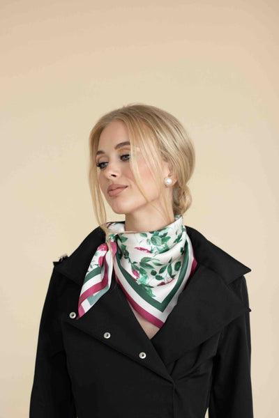 Woman wearing a black coat with a floral scarf on a beige background