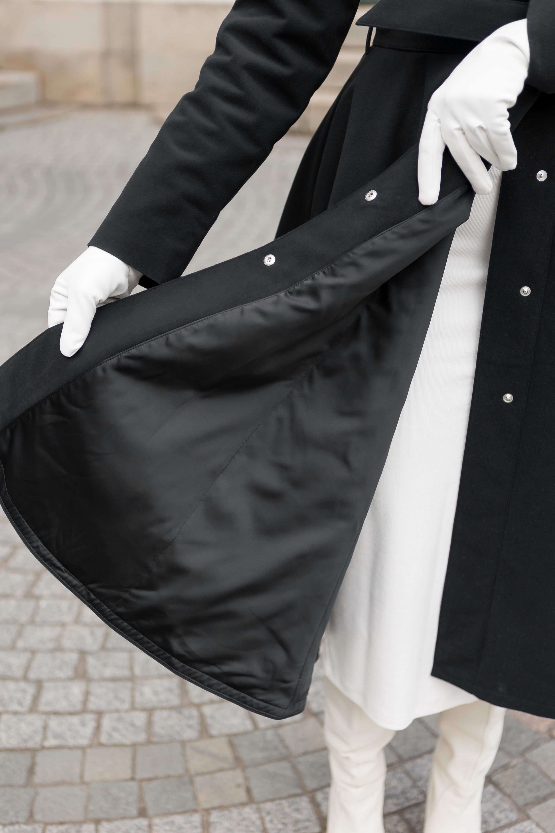 Timeless black winter coat with flared silhouette and adjustable hood, a statement of winter fashion