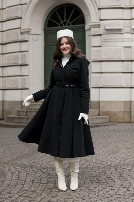 Woman wearing the Obsidian Frost midi black winter coat by RainSisters, styled with detachable hood and belt.