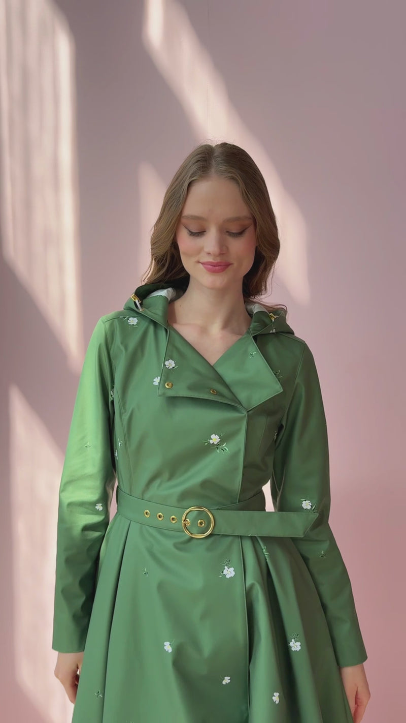 Video of model walking and wearing a green floral waterproof trench coat with adjustable hood and belt – romantic spring fashion for women