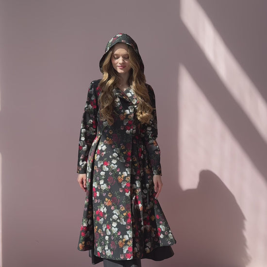Video still of model walking in Rose Garden coat – floral outerwear in motion, worn with matching tie belt.