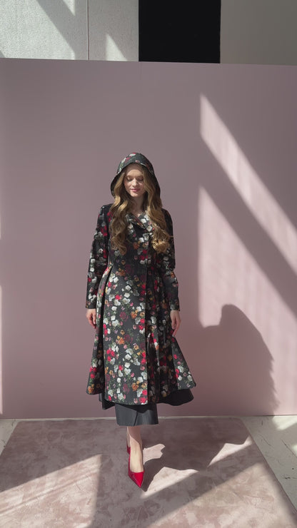 Video still of model walking in Rose Garden coat – floral outerwear in motion, worn with matching tie belt.