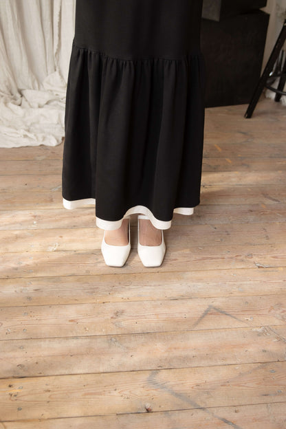 Black viscose formal dress with maxi length, slim fit bodice, flared hem, and graceful ruffle details.